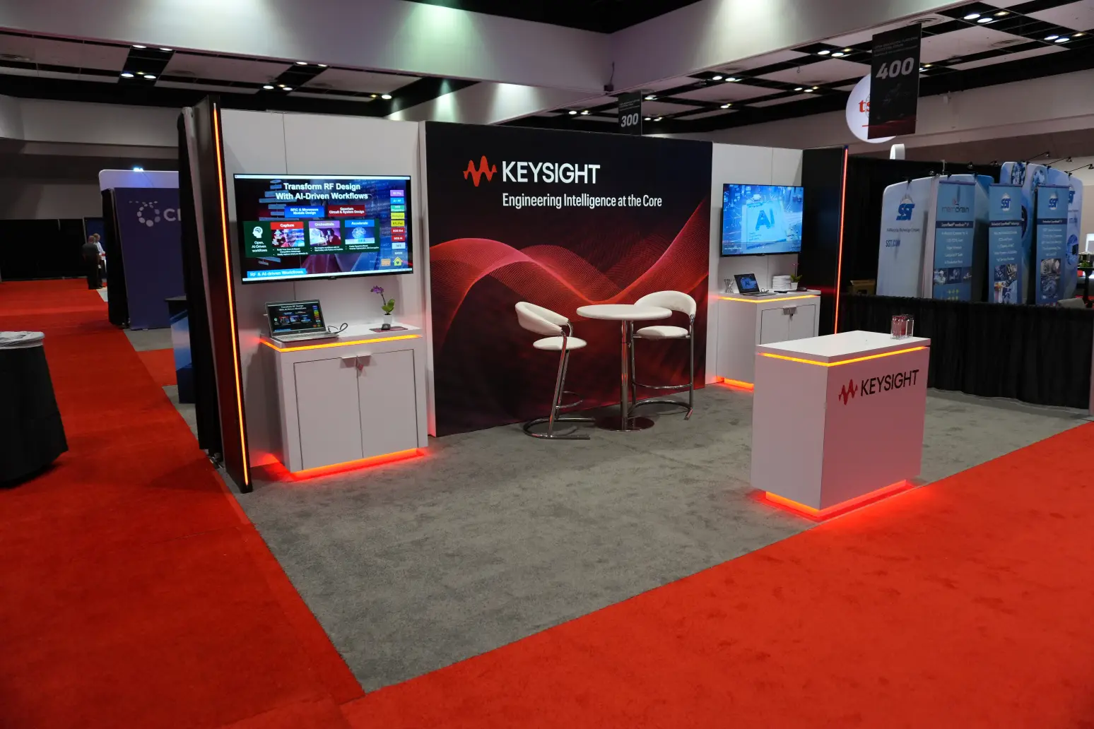 Side profile of Keysight booth showing return wall and neon fin