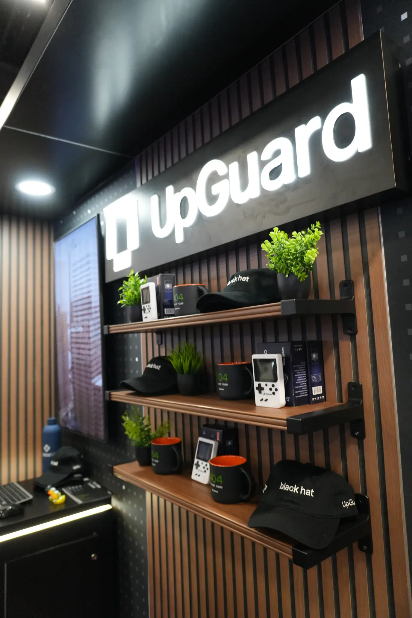 Straiker AI custom island trade show booth featuring illuminated LED video tower display and overhead hanging sign, built by Elevate Exhibits.